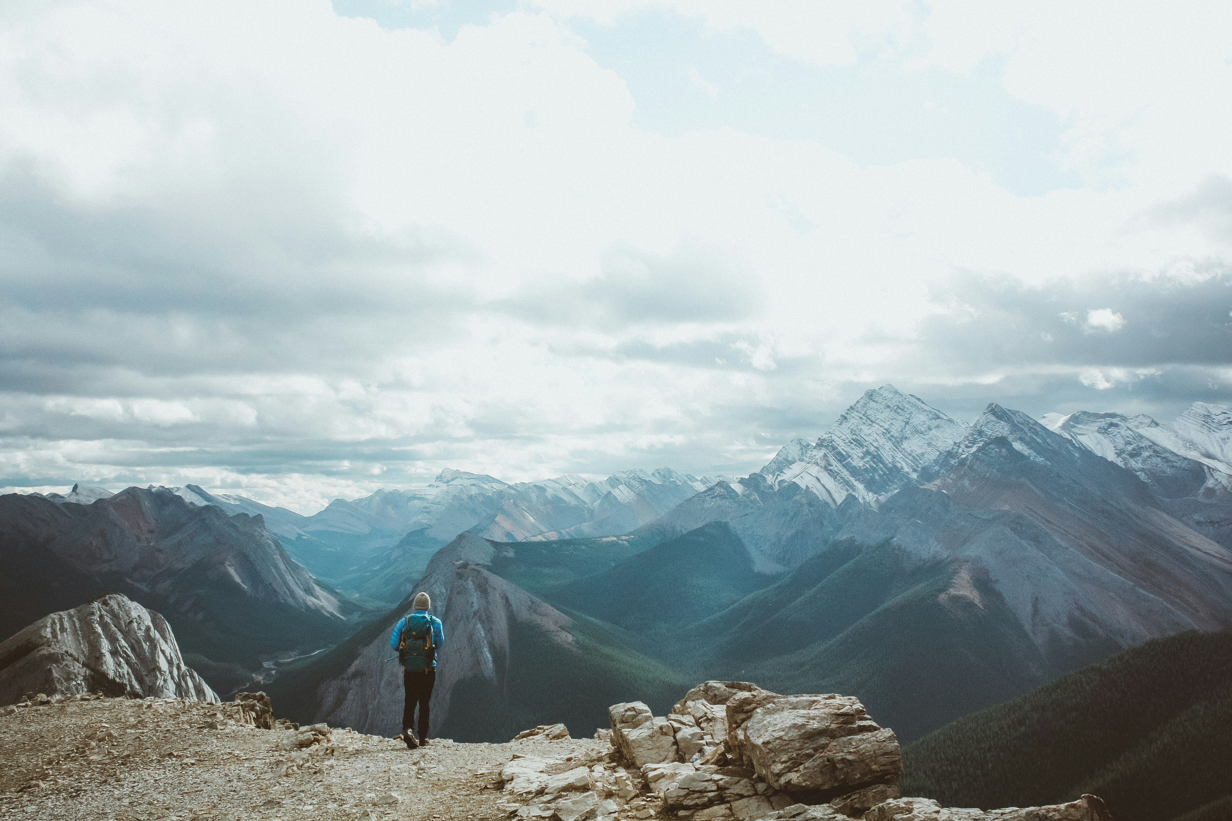 person in black jacket standing on rocky mountain during daytime